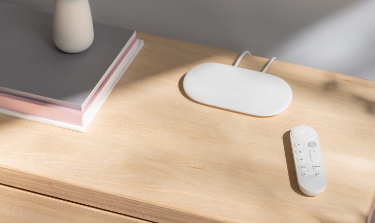 Google TV Streamer and its remote sit side by side on a table.