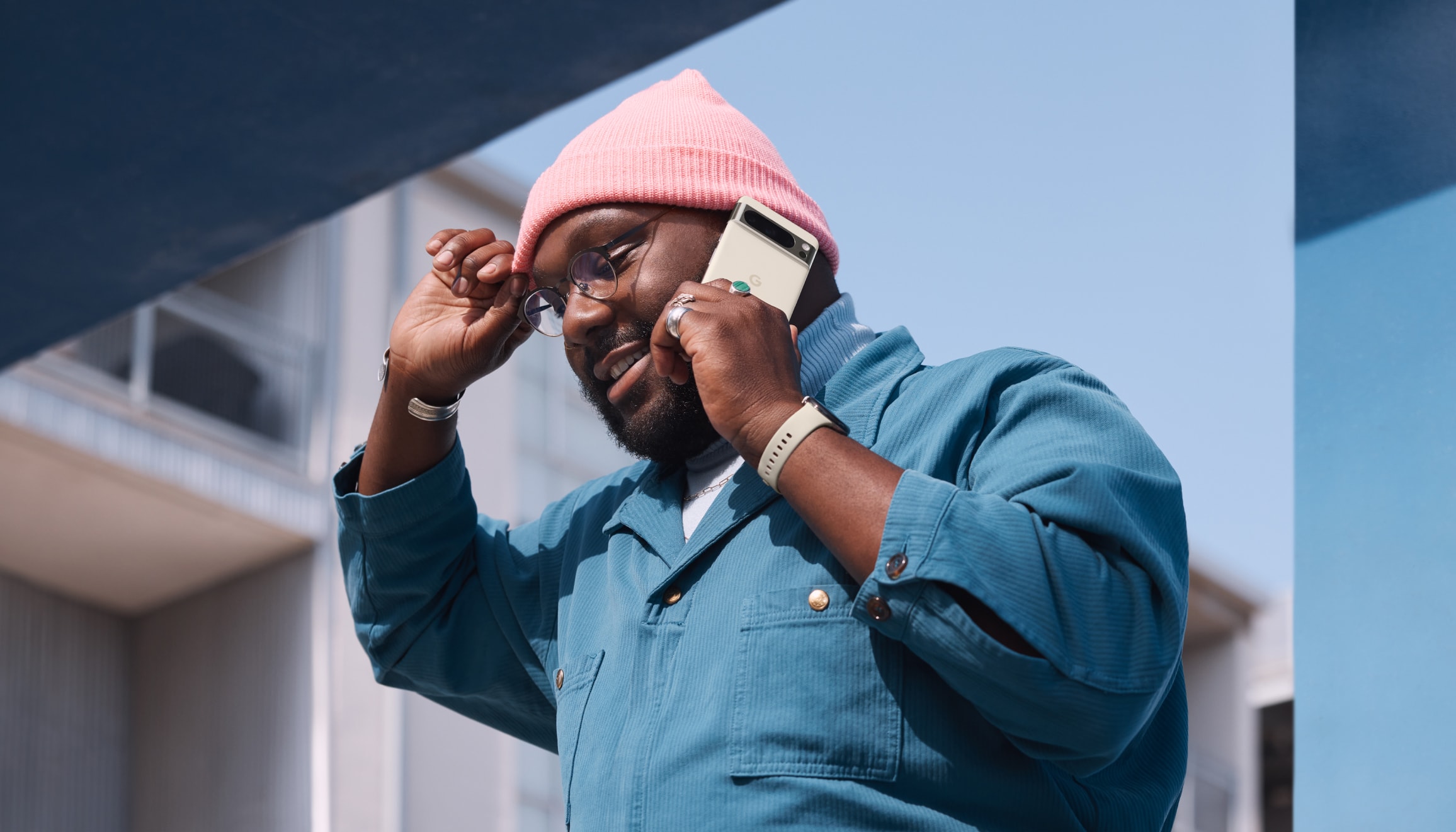 A person holds their Pixel 8 Pro while walking outside.